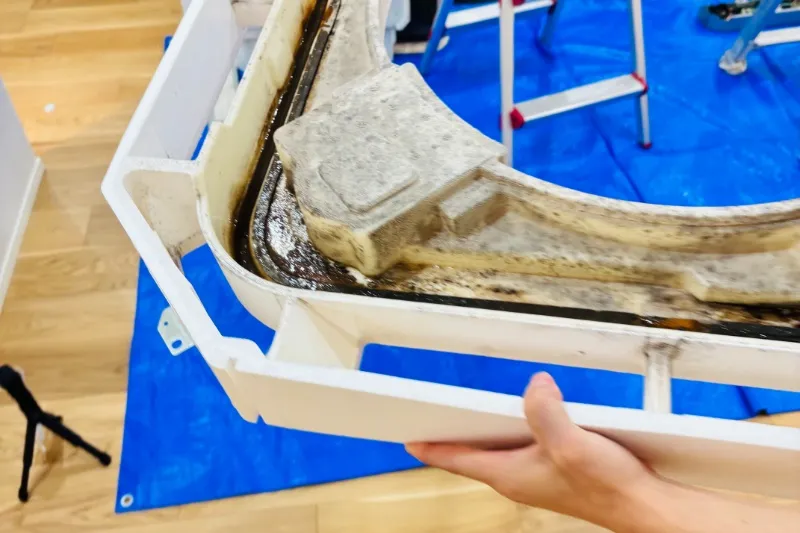 エアコンクリーニングで取り外した、カビや汚れで真っ黒になったドレンパン