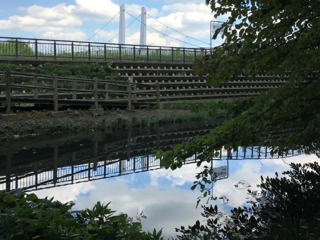 志木市のいろは親水公園。川に架かる歩道橋と水面に映り込む空の風景